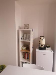 una cocina con una estantería blanca junto a una nevera blanca en Casetta Russo, en Meta
