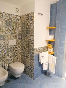 Baño de azulejos azules con aseo y lavamanos en Casetta Russo, en Meta