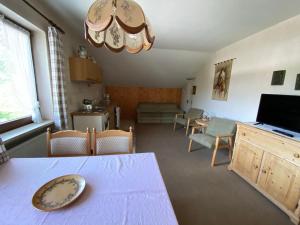 ein Wohnzimmer mit einem Esstisch und einem Wohnzimmer in der Unterkunft Gästehaus Buchinger in Bayerisch Eisenstein