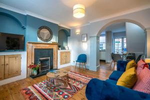 a living room with a blue couch and a fireplace at Two bedroom house in Canterbury City Centre in Canterbury