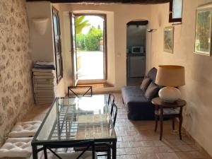 sala de estar con sofá y mesa de cristal en La Petite Maison, en Saint-Paul-de-Vence