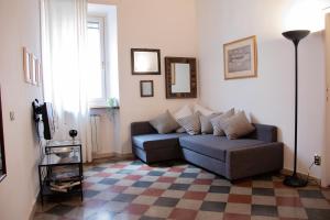sala de estar con sofá y suelo a cuadros en The Best Rent - Piazza di Firenze Apartment, en Roma