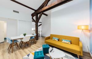 uma sala de estar com um sofá amarelo e uma mesa em Aux portes de Bordeaux Le Loft Samba MindUrGuest em Bègles