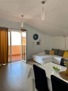 a living room with a bed and a couch and a table at Apartments Ivana in Zubovići