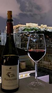 - une bouteille de vin à côté d'un verre de vin dans l'établissement Athens Goddess, à Athènes