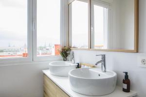 ein Badezimmer mit zwei Waschbecken und zwei Fenstern in der Unterkunft Stylish City Vacation Gran Canaria in Las Palmas de Gran Canaria