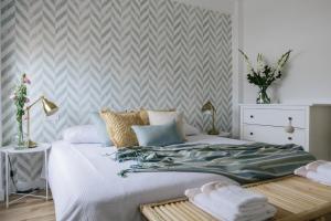Un dormitorio con una gran cama blanca y una pared en Stylish City Vacation Gran Canaria, en Las Palmas de Gran Canaria