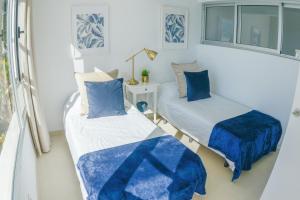 サンアグスティンにあるSunny Sea View Accommodation Gran Canariaの青い枕が備わる小さな部屋のベッド2台
