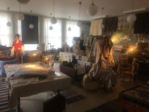 Eine Frau steht in einem Raum voller Möbel. in der Unterkunft Långhedgården Bed & Breakfast in Alfta