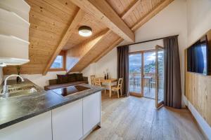 cocina con techos de madera y comedor con mesa en Chalet Schlossberg Weißhorn en Nova Ponente
