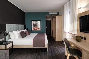 a hotel room with a large bed and a television at be.HOTEL in St. Julianʼs