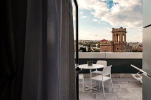 a view from a balcony with a table and chairs at be.HOTEL in St. Julianʼs