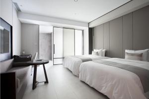 pokój hotelowy z 2 łóżkami i stołem w obiekcie Manho Hotel w mieście Taizhong