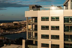 a tall white building with a view of the ocean at be.HOTEL in St. Julianʼs