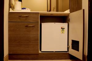 a small refrigerator in a kitchen with a cabinet at Wongdhen House in New Delhi