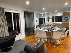 a dining room and living room with a table and chairs at Ocean Front East End Beach House in New Plymouth