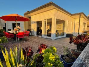 a patio with a table and chairs on a deck at Ocean Front East End Beach House in New Plymouth