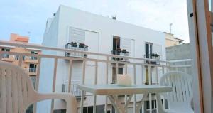 einen Tisch und Stühle auf einem Balkon mit Blick auf ein Gebäude in der Unterkunft Cozy apartment + parking Playa San Juan in Guía de Isora