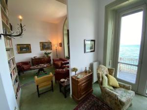 uma sala de estar cheia de mobiliário e uma grande janela em Liberty em Stresa