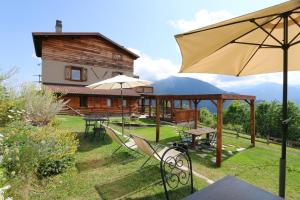 a patio with chairs and an umbrella and a house at Lou Subric in Stroppo