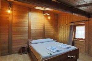 a bedroom with a bed in a room with wooden walls at Lou Subric in Stroppo