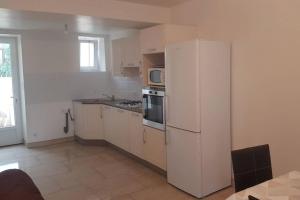 a kitchen with a white refrigerator and a microwave at Maison de bourg avec extérieur. in Grez-en-Bouère