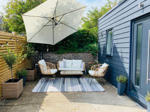 - une terrasse avec 2 chaises et un parasol dans l'établissement Old Town Oasis, à Eastbourne