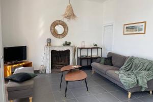 ein Wohnzimmer mit einem Sofa und einem Kamin in der Unterkunft Agon-Coutainville, villa bord de mer in Agon Coutainville