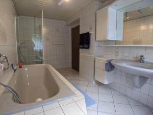 Un baño blanco con bañera y lavabo. en Ferienwohnung Kerstin, en Bernkastel-Kues