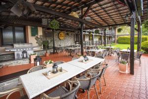 patio ze stołami, krzesłami i sprzętem do grillowania w obiekcie Hotel El Greco w mieście Rožnov pod Radhoštěm