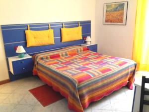 1 dormitorio con cama azul y almohadas amarillas en Le Conchiglie, en Levanto