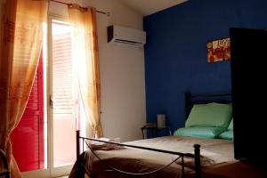 sypialnia z niebieskimi ścianami i łóżkiem z oknem w obiekcie Casa vacanza in villa con piscina! w mieście Triscina +22 zdjęcia