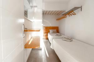 サンアグスティンにあるMagical Sea View Accommodation Gran Canariaの白い壁の小さな部屋のベッド2台