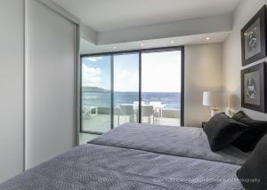 a bedroom with a bed and a view of the ocean at Penthouse Over The Sea in Las Palmas de Gran Canaria