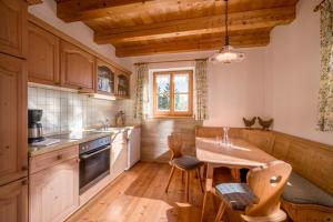 a kitchen with wooden cabinets and a table with chairs at Großhuberhof in Kiefersfelden
