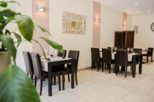 a dining room with black tables and black chairs at Logis Le Saint Hubert in Haybes