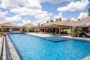 - une piscine dans un complexe avec des parasols en chaume dans l'établissement Kabana Hotel, à Prea