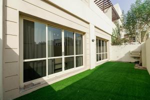 a garden with green grass next to a building at Havana Villas Al Barsha in Dubai