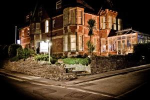 a large brick house with a stone wall at The Castleton in Swanage