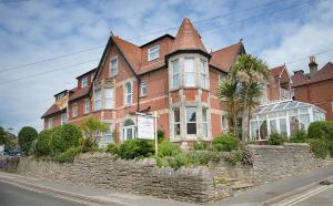 a large red brick house with a stone wall at The Castleton in Swanage
