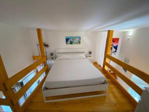 a bedroom with a bed and wooden floors at Magi - Zeus in Ponza