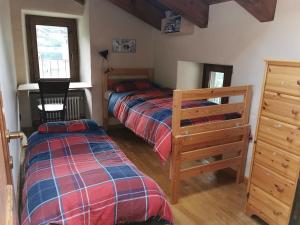 Affascinante appartamento ai piedi dell'ovovia في كورمايور: غرفة نوم بها سريرين ومكتب