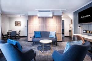 a waiting room with blue chairs and a couch at Powerhouse Hotel Tamworth by Rydges in Tamworth