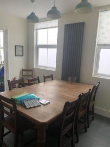 a dining room with a wooden table and chairs at Beautiful Tenby House, pets allowed in Tenby