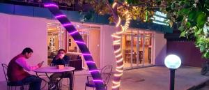 two people sitting at a table with purple lights at Everland Kathmandu Hotel in Kathmandu