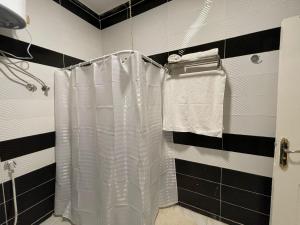 a bathroom with a shower with a white shower curtain at Kemet Apartment luxor in Luxor