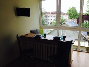 una mesa con dos vasos junto a una ventana en A Cozy Central Studio, en Druskininkai