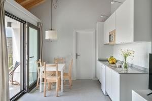 a kitchen with white cabinets and a table and chairs at BAO 4 / APARTAMENTO CON TERRAZA in Somo