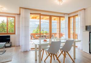 a dining room with a white table and chairs at Panoramapark Soleil Chalet A in Wengen