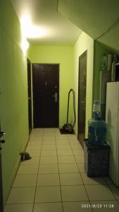 pasillo con puerta negra y suelo de baldosa en Hostel Yasen, en Perm